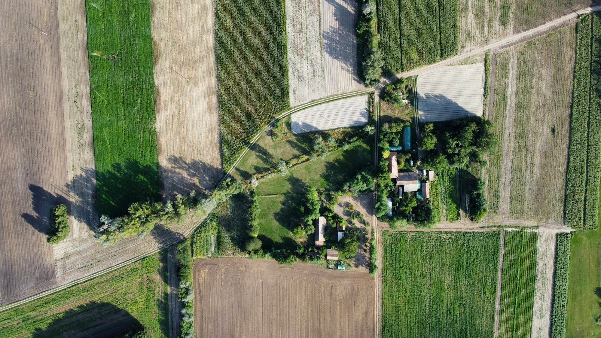 Vue aérienne d'un hameau entouré de champs et de haies